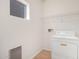 Bright laundry room with a white washer, overhead rack, wood floors, and a small window for natural light at 2652 E Riviera Dr, Chandler, AZ 85249
