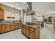 Open kitchen design with wooden cabinets, granite countertops, island cooktop, and stainless steel range hood at 27892 N 108Th Way, Scottsdale, AZ 85262