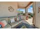 Covered patio with comfortable seating, built-in grill, and views of the landscaped backyard at 27892 N 108Th Way, Scottsdale, AZ 85262