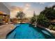 Beautiful backyard pool with stone accents, desert landscaping, and an outdoor dining area at 27892 N 108Th Way, Scottsdale, AZ 85262