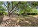 Lush backyard with mature trees, brick accents, and ample space for outdoor activities at 302 E Orange Dr, Phoenix, AZ 85012