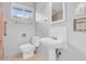 Bathroom featuring a pedestal sink, toilet, and window for natural light with light blue paint at 302 E Orange Dr, Phoenix, AZ 85012