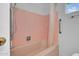 Bathroom showcasing a pink tiled shower with a shower curtain, handrail, and neutral paint at 302 E Orange Dr, Phoenix, AZ 85012