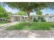 Charming single-story home with mature shade tree, lush front lawn, and attached carport at 302 E Orange Dr, Phoenix, AZ 85012