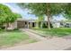 Traditional-style home with a well-maintained front lawn, mature shade tree and covered parking at 302 E Orange Dr, Phoenix, AZ 85012