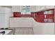 The kitchen featuring tiled countertops and backsplash, along with ample white cabinetry and retro fixtures at 302 E Orange Dr, Phoenix, AZ 85012