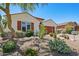 Charming single-story home featuring desert landscaping, a brown two-car garage, and shutters at 30406 N 54Th St, Cave Creek, AZ 85331