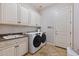 Well-equipped laundry room featuring washer, dryer, utility sink, granite countertop and ample cabinet storage at 30406 N 54Th St, Cave Creek, AZ 85331