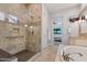 Elegant main bathroom with tiled shower, soaking tub, and granite countertop, leading to the main bedroom at 30406 N 54Th St, Cave Creek, AZ 85331