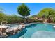 Relaxing backyard featuring a sparkling pool and spa with rock accents, surrounded by lush landscaping at 30406 N 54Th St, Cave Creek, AZ 85331