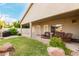 Covered back patio with outdoor seating overlooking the manicured lawn and lush landscaping at 321 W Brooks St, Gilbert, AZ 85233