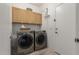 Convenient laundry room showcasing side-by-side washer and dryer, ample cabinet space, and tiled floors at 321 W Brooks St, Gilbert, AZ 85233