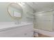 Bright bathroom featuring a large round mirror, floating shelves, and a walk-in shower at 3514 E Desert Willow Rd, Phoenix, AZ 85044
