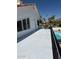A charming white home featuring an inviting balcony overlooking the backyard swimming pool and a view of picturesque palm trees at 3514 E Desert Willow Rd, Phoenix, AZ 85044