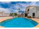 A large in-ground pool with surrounding landscaping and a clear blue sky at 3514 E Desert Willow Rd, Phoenix, AZ 85044