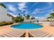 Blue swimming pool surrounded by desert landscaping, lounge chairs, and a privacy fence at 3514 E Desert Willow Rd, Phoenix, AZ 85044