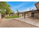 Expansive backyard featuring a covered patio, lush lawn, mature trees, and sparkling pool at 3619 E Marmora St, Phoenix, AZ 85032