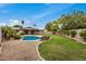 Large backyard featuring a pool, patio, green grass and tropical landscaping at 3619 E Marmora St, Phoenix, AZ 85032