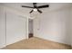 Bright bedroom featuring neutral carpet, ceiling fan, and closet at 3619 E Marmora St, Phoenix, AZ 85032
