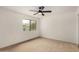 Bedroom featuring carpet, a ceiling fan, and a large window for ample natural light at 3619 E Marmora St, Phoenix, AZ 85032