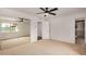 Bright bedroom featuring neutral carpet, ceiling fan, and closet with mirrored doors at 3619 E Marmora St, Phoenix, AZ 85032