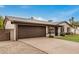 Single-story home boasting a spacious driveway leading to a two-car garage and a well-manicured front lawn at 3619 E Marmora St, Phoenix, AZ 85032