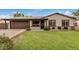 Charming single-story home with a lush green lawn, well-maintained landscaping, and neutral color palette at 3619 E Marmora St, Phoenix, AZ 85032