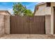 Wooden privacy gate providing a secure entrance to the backyard, set against a backdrop of desert landscaping at 3619 E Marmora St, Phoenix, AZ 85032
