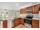 Kitchen with stainless steel appliances, wooden cabinets, and an open view to the backyard at 3619 E Marmora St, Phoenix, AZ 85032
