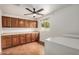 Laundry room featuring a ceiling fan, brown cabinets, and a tile floor at 3619 E Marmora St, Phoenix, AZ 85032