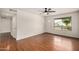 Bright, airy living room featuring gleaming hardwood floors, a ceiling fan, and a large window at 3619 E Marmora St, Phoenix, AZ 85032