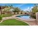 Backyard swimming pool bordered by lush green grass and a unique paved walkway at 3619 E Marmora St, Phoenix, AZ 85032