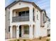 A beautiful two-story townhome featuring stucco exterior, black trim, and a balcony overlooking the front yard at 4063 E Amoroso Dr, Gilbert, AZ 85296