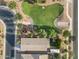 An aerial view shows the roof of a home next to a well-manicured green space with mature landscaping at 41138 N Soap Berry St, Queen Creek, AZ 85140