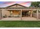 Inviting back patio featuring a pergola with string lights, seating, and a well-maintained lawn at 41138 N Soap Berry St, Queen Creek, AZ 85140