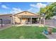 A backyard with a covered patio, a small seating area, green grass, and a block wall at 41138 N Soap Berry St, Queen Creek, AZ 85140