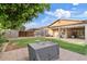 This large backyard offers a covered patio, block wall, green grass, and an exterior storage area at 41138 N Soap Berry St, Queen Creek, AZ 85140