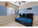 This comfortable bedroom features blue accent walls, wood-look floors, and a ceiling fan at 41138 N Soap Berry St, Queen Creek, AZ 85140