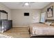 This bedroom has a gray dresser, a mounted TV and wood floors at 41138 N Soap Berry St, Queen Creek, AZ 85140