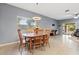 This dining room has a wood table with six chairs and a window with light coming through at 41138 N Soap Berry St, Queen Creek, AZ 85140