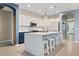 Open-concept kitchen features a large island, white cabinets, stainless appliances and counter seating at 41138 N Soap Berry St, Queen Creek, AZ 85140