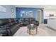 Cozy living room with a leather sofa, a round area rug, and an open view of the kitchen at 41138 N Soap Berry St, Queen Creek, AZ 85140