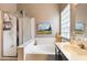 Bright bathroom featuring a tub with glass shower door and a vanity at 420 N Leoma Ln, Chandler, AZ 85225