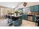 Bright kitchen featuring teal cabinets, granite countertops, stainless steel appliances and a breakfast bar with seating at 420 N Leoma Ln, Chandler, AZ 85225