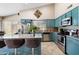 Bright kitchen featuring teal cabinets, granite countertops, stainless steel appliances and a convenient breakfast bar at 420 N Leoma Ln, Chandler, AZ 85225