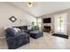 Cozy living room featuring vaulted ceiling, tile flooring, a fireplace, and a comfortable sectional sofa at 420 N Leoma Ln, Chandler, AZ 85225