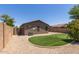 A fenced backyard with gravel landscaping, artificial grass, and shrubbery at 42347 W Bunker Dr, Maricopa, AZ 85138
