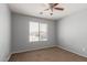 Bedroom including a ceiling fan, carpet, and a large window for natural light at 42347 W Bunker Dr, Maricopa, AZ 85138
