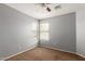 Bedroom features carpet, a ceiling fan, and two large windows for natural light at 42347 W Bunker Dr, Maricopa, AZ 85138