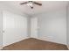 A simply decorated bedroom with a ceiling fan and a closet with double doors at 42347 W Bunker Dr, Maricopa, AZ 85138
